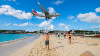 American Airlines plane flying over St. Maarten beach to land at aiport
