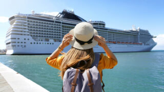 Woman in a Hat in Front of Cruise Ship