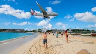 American Airlines plane flying over St. Maarten beach to land at aiport