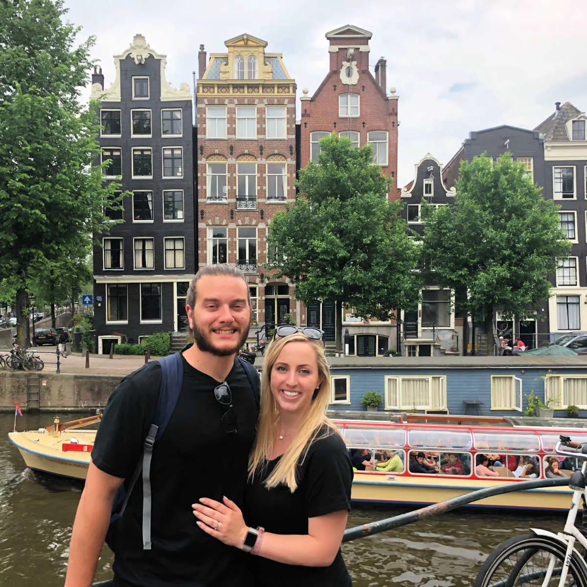 Man and woman in front of Amsterdam canal. Tyler and Liz Fox.heic